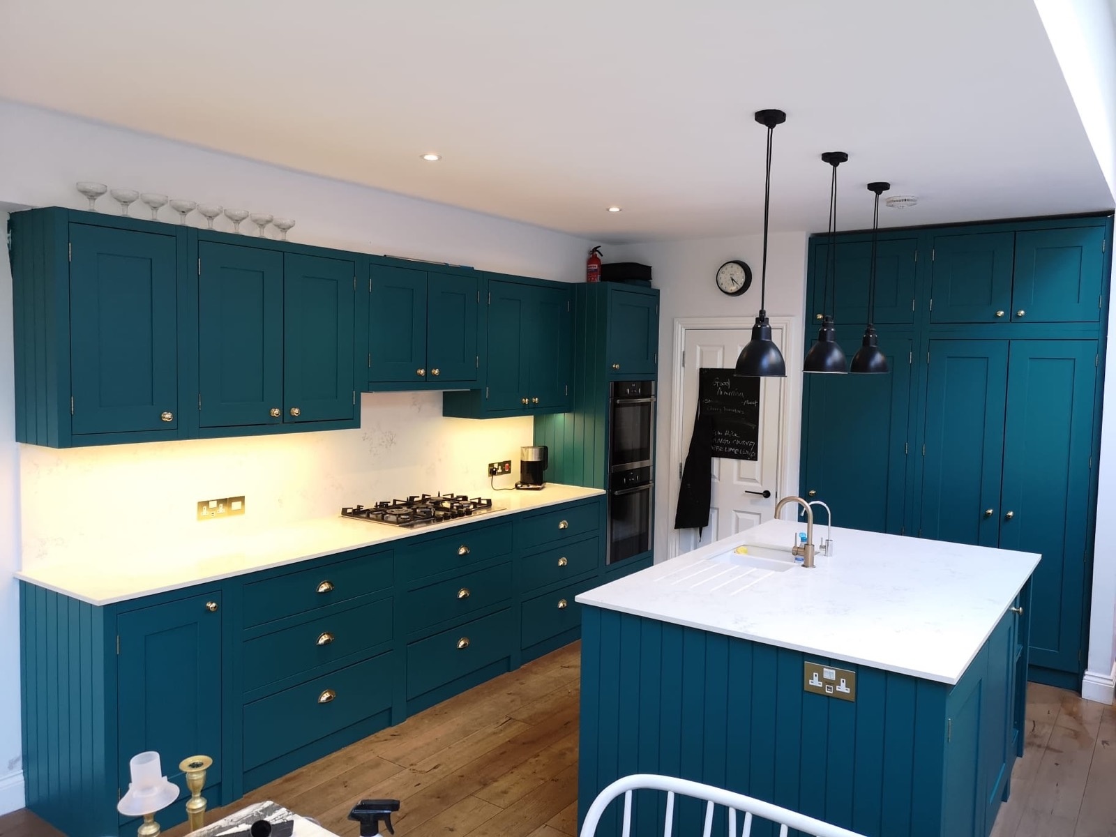 Bespoke teal painted kitchen with brass hardware, marble worktop and island